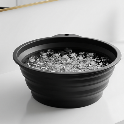 Black collapsible basin with ice cubes on a white surface